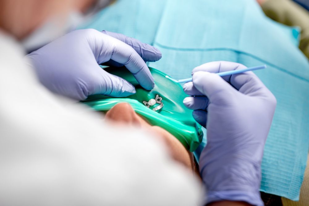 A dentist is working on a patient 's teeth in a dental office.