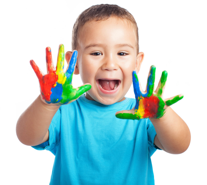 Smiling child with paint-covered hands held up against a white background