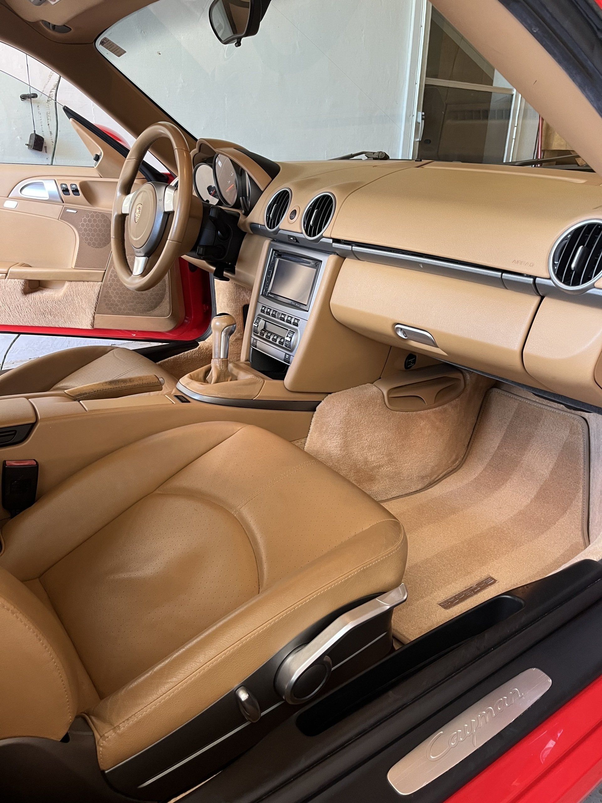 The interior of a red sports car with tan leather seats 