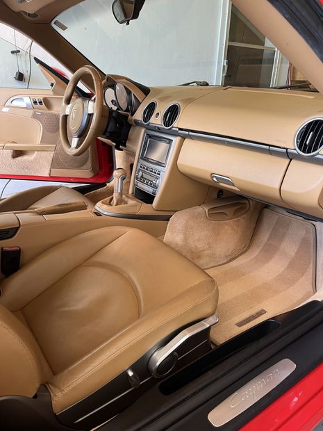 The interior of a red sports car with tan leather seats 