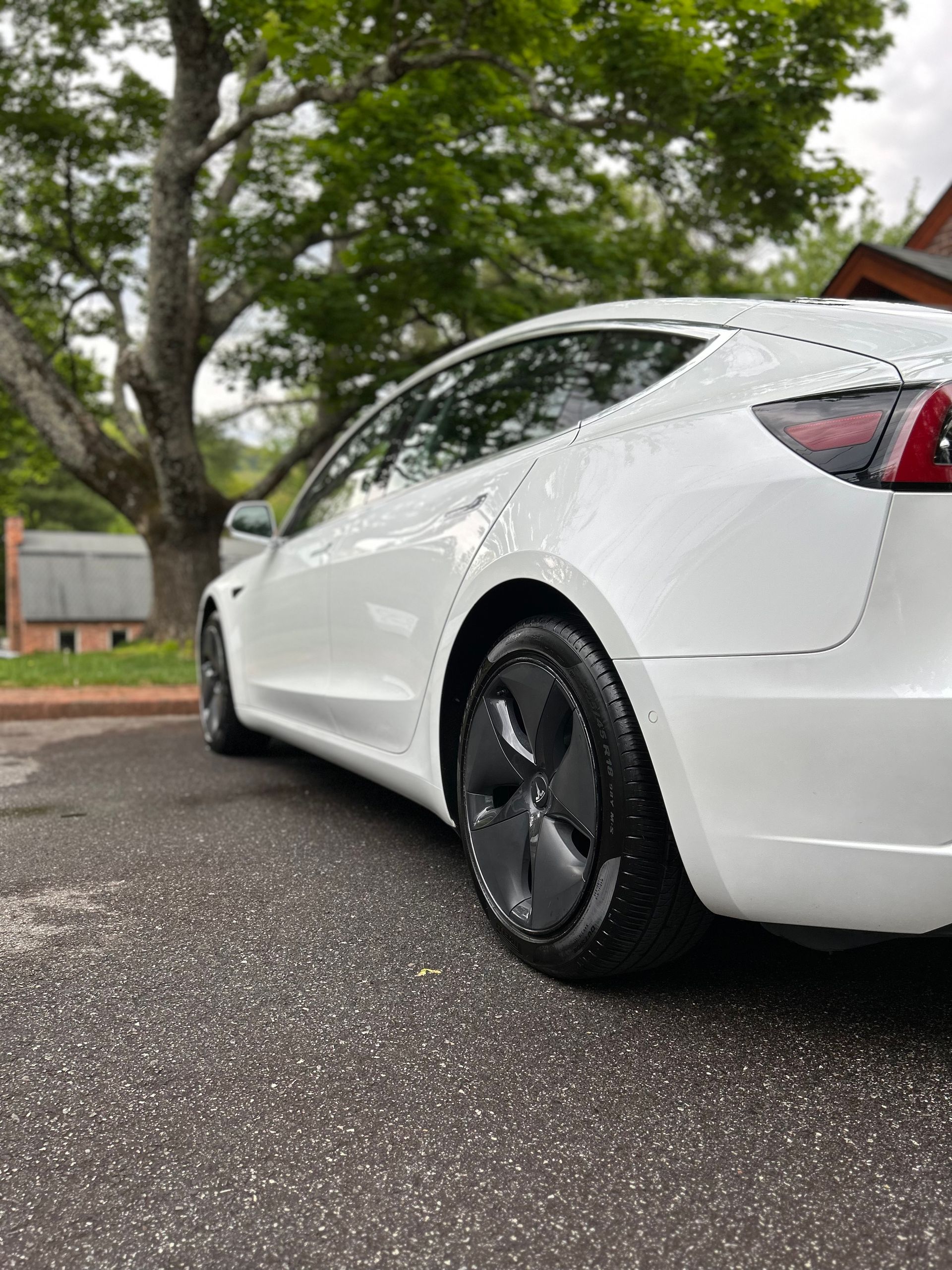 A white tesla model 3 is parked on the side of the road. Wash and Wax. Exterior Detailing. Mobile Detailing