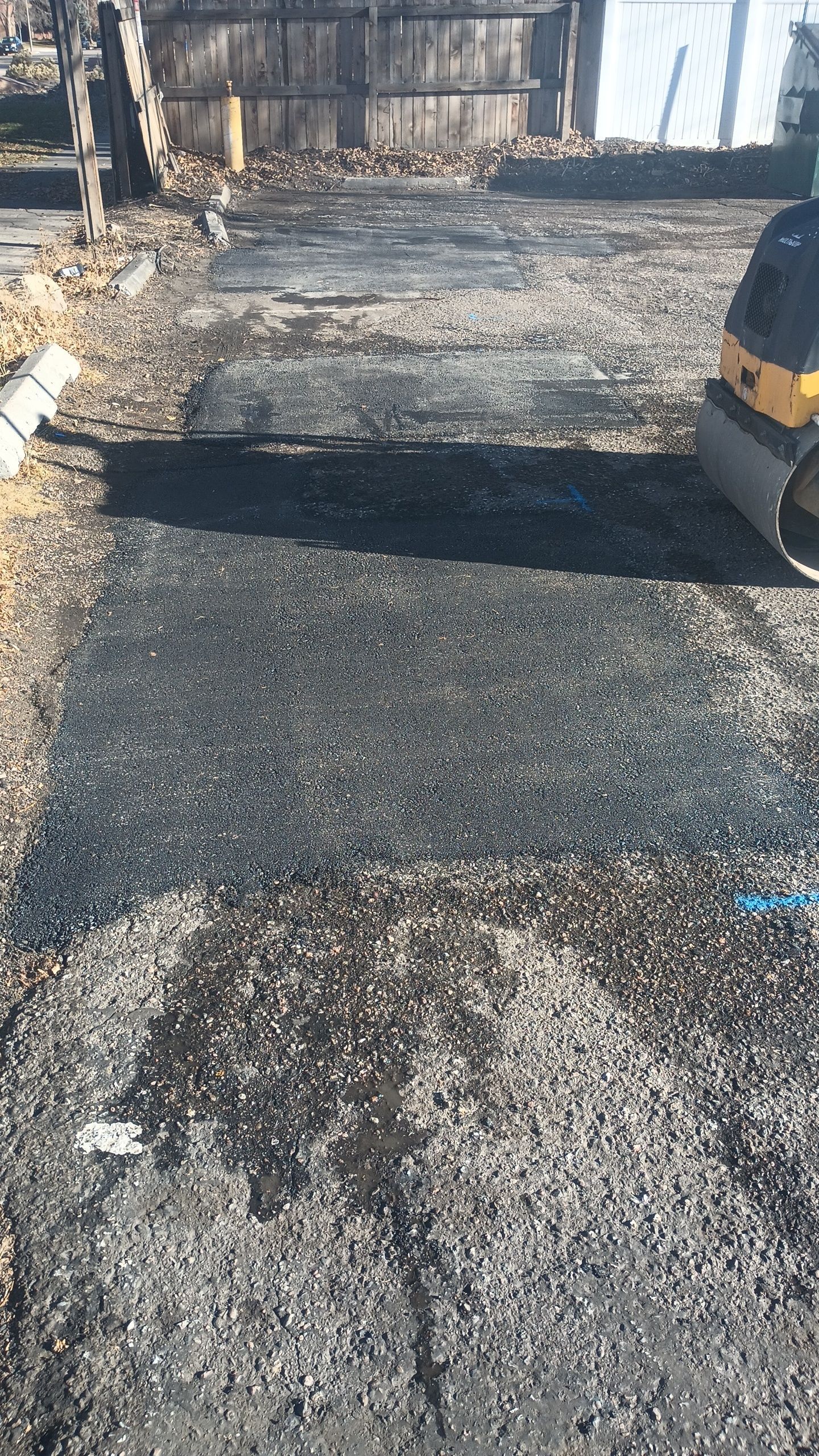 A roller is sitting on top of a pile of asphalt.