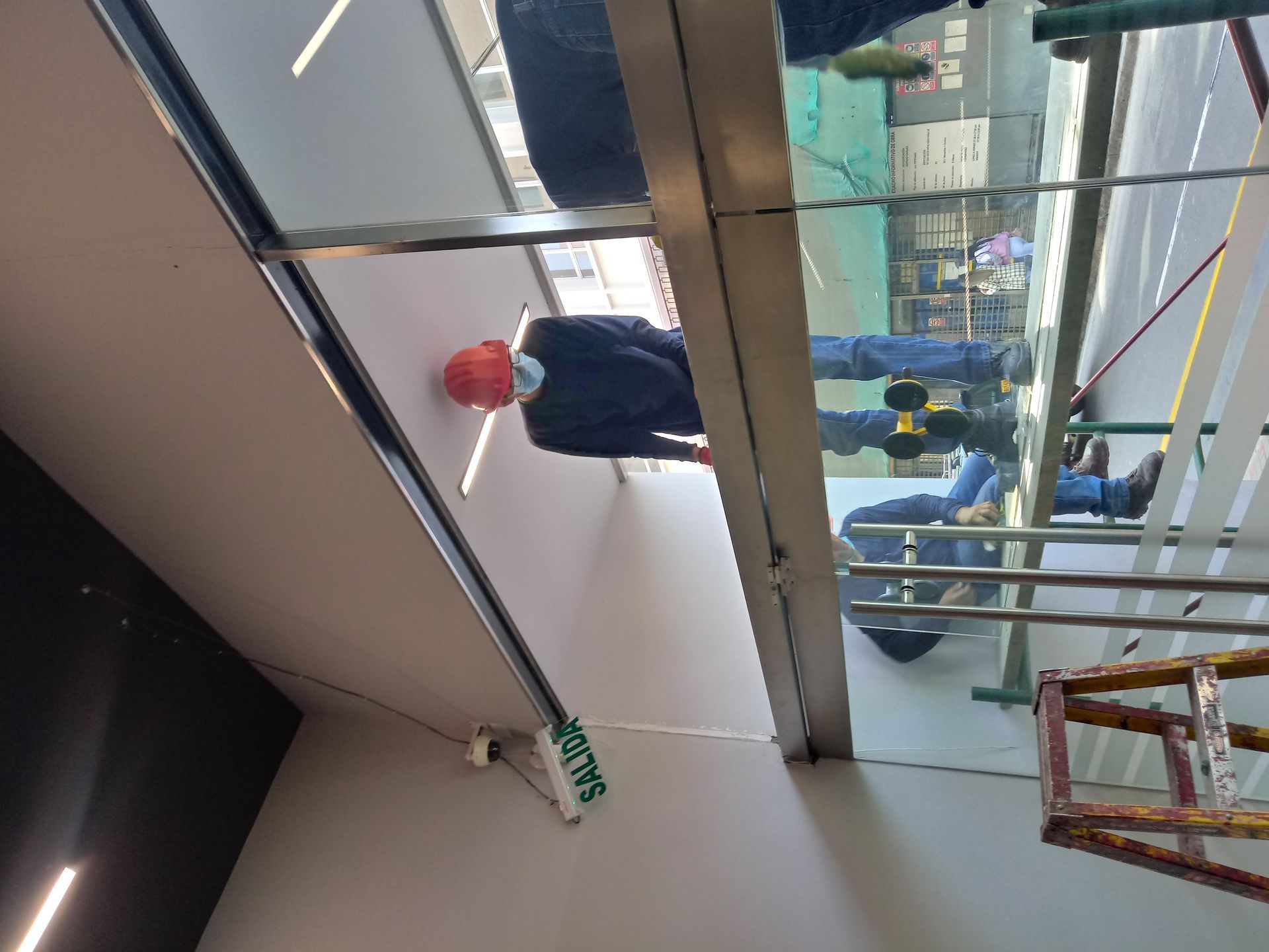 Un moderno edificio de oficinas de cristal y metal contra un cielo azul.
