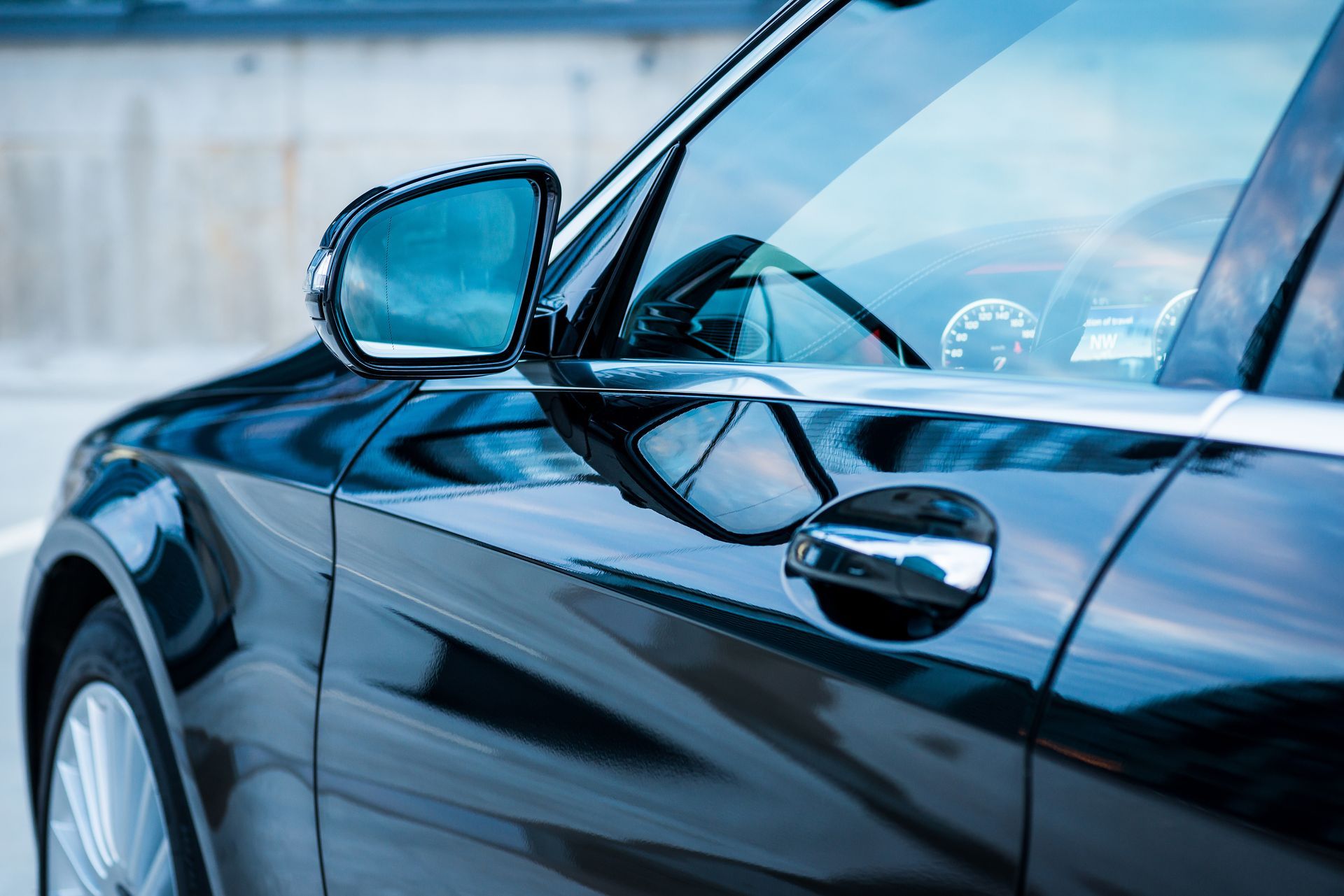 Modern car exterior. Driver's door, mirror, dashboard.