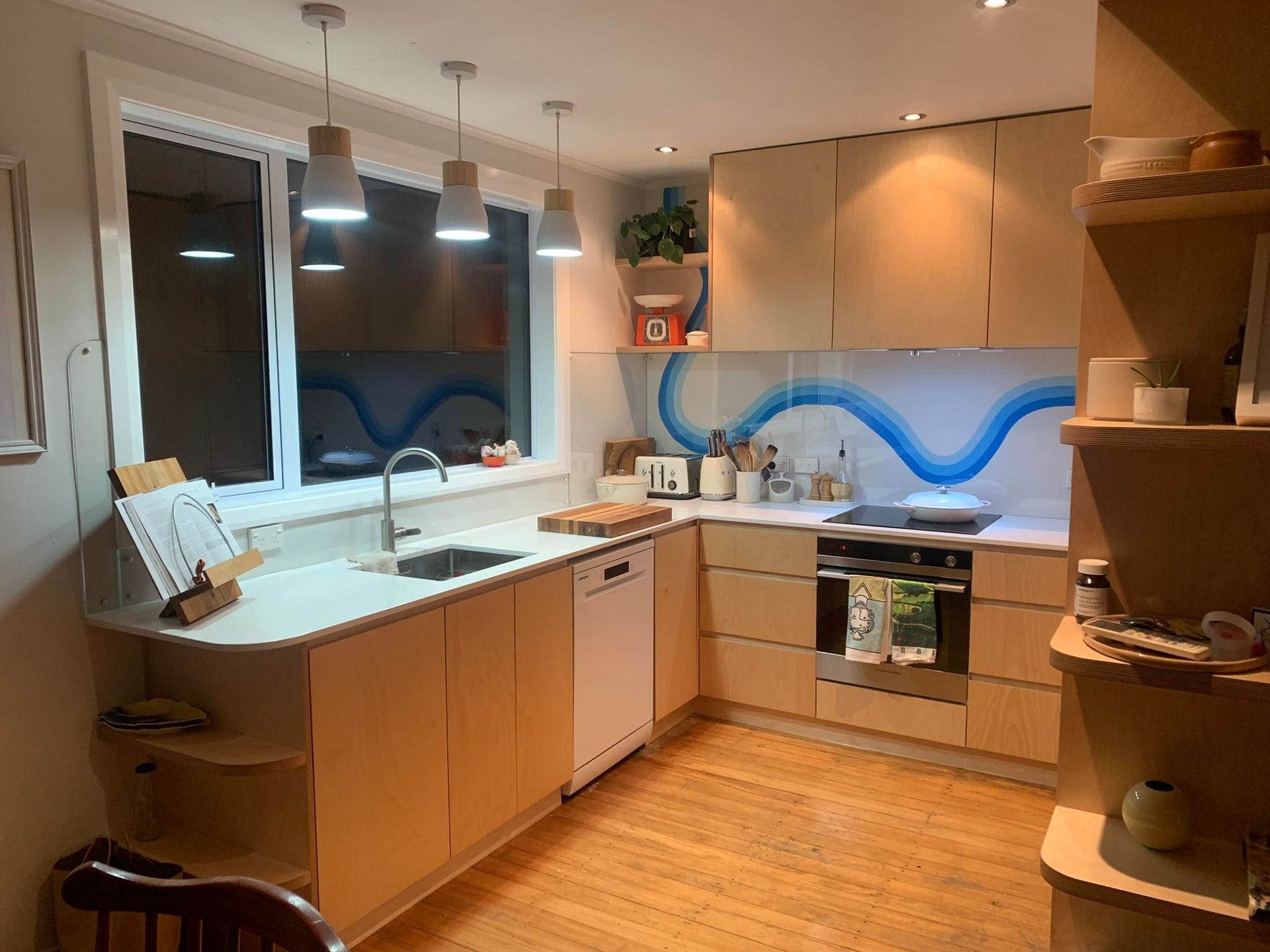 A kitchen with wooden cabinets , stainless steel appliances , a sink , and a window.