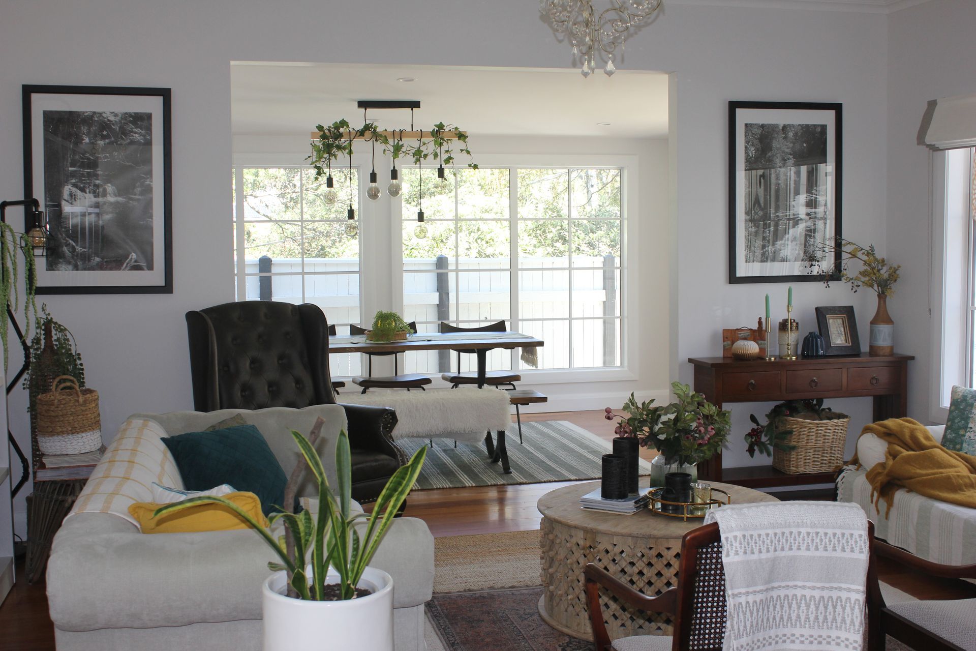 A living room with a couch , chair , table , and potted plant.