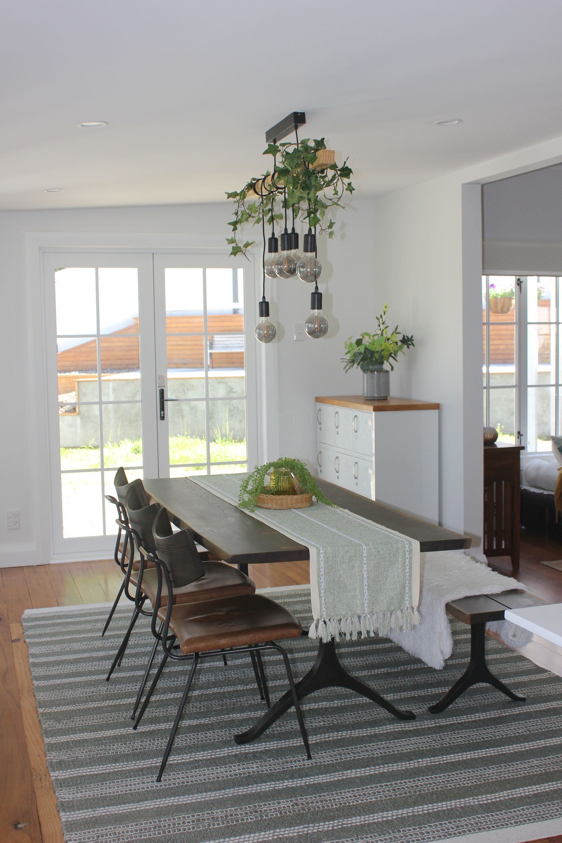 A dining room with a table and chairs and a rug.
