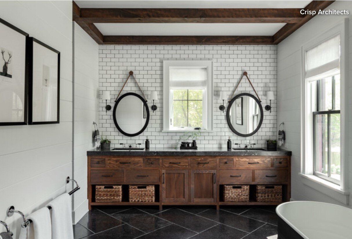 A bathroom with two sinks , two mirrors and a tub.