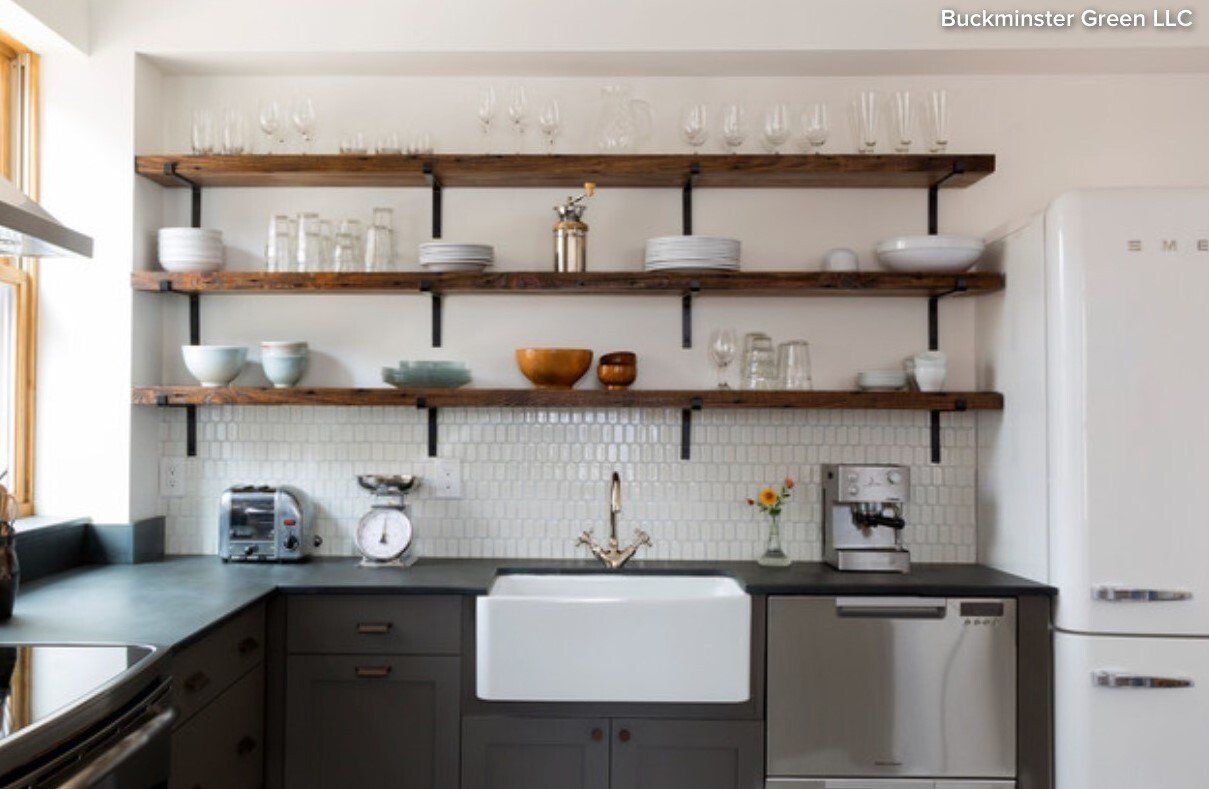 A kitchen with a sink , refrigerator , and shelves.