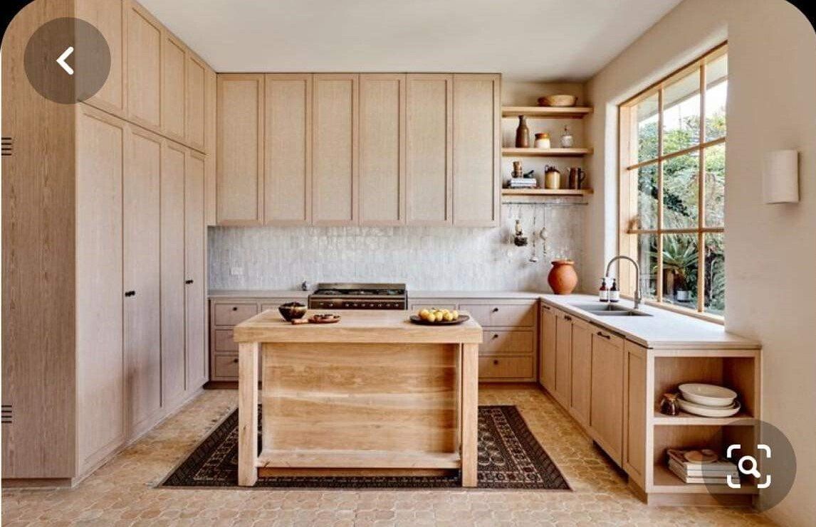 A kitchen with wooden cabinets and a wooden island