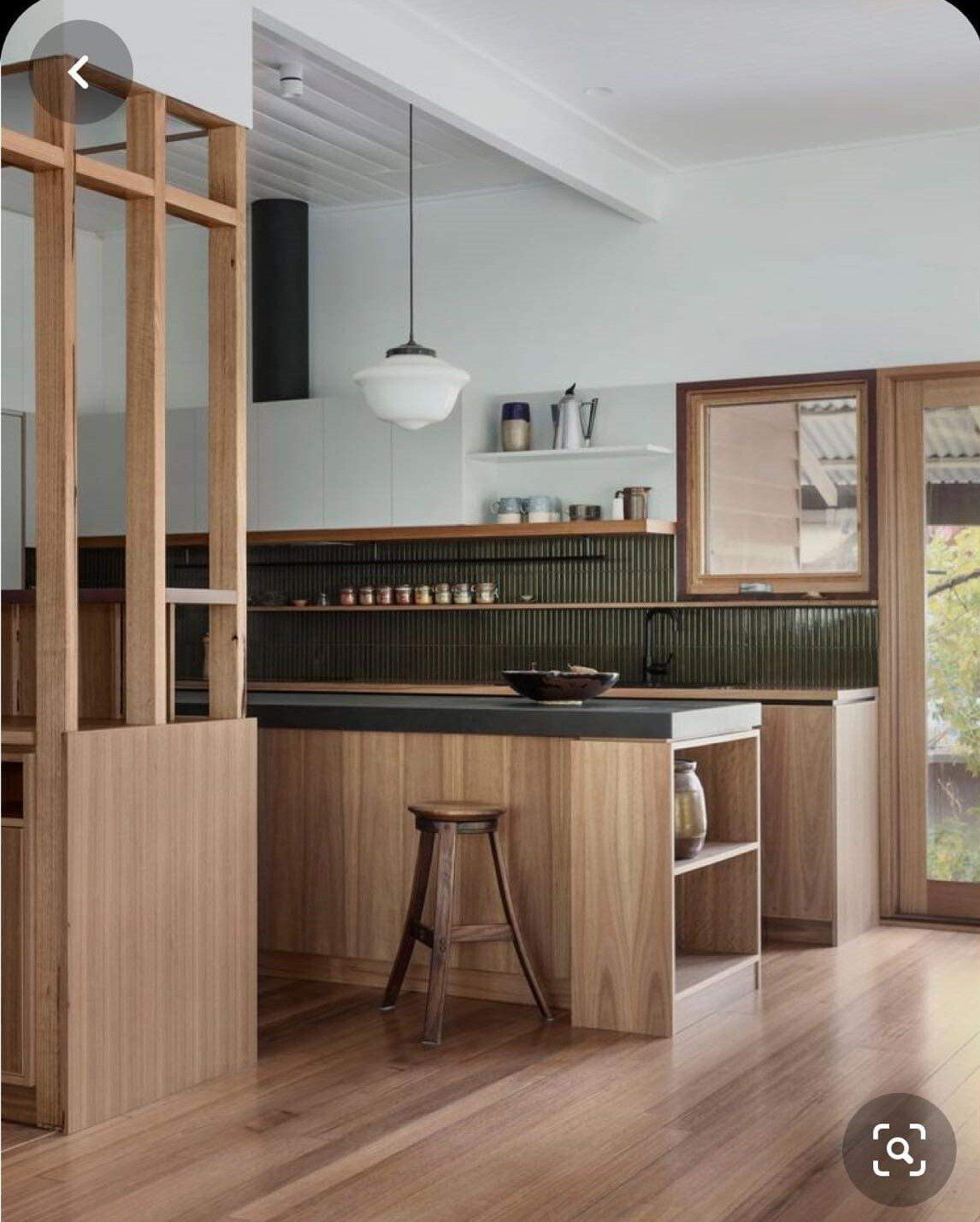 A kitchen with a wooden island and a stool