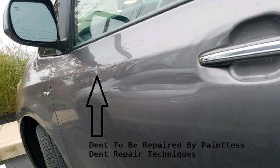 Gray car door with dent marked by an arrow, captioned 