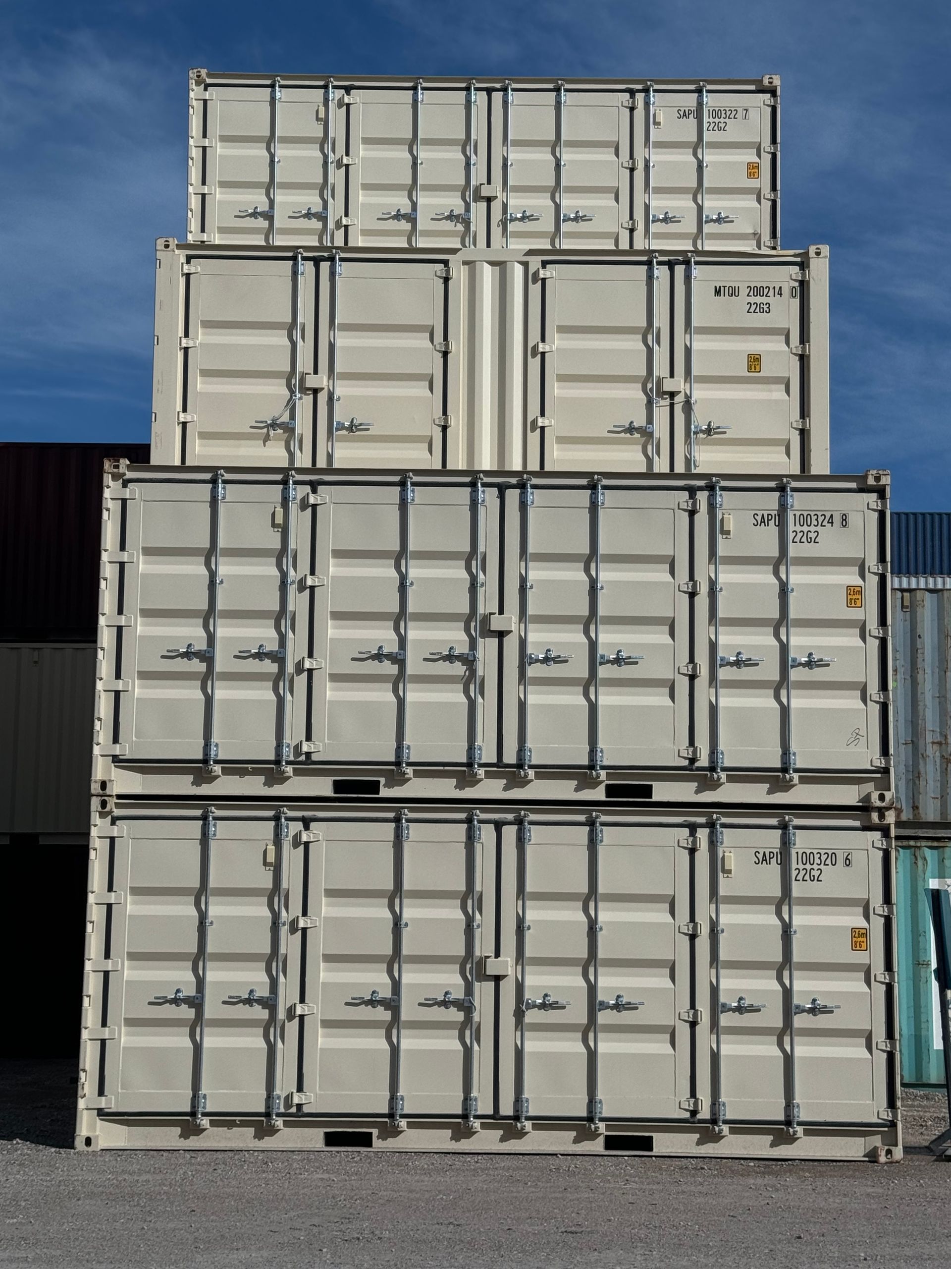 Stacked white shipping containers against a blue sky