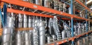 Galvanised metal ductwork elbows and straight sections inside a wire cage.