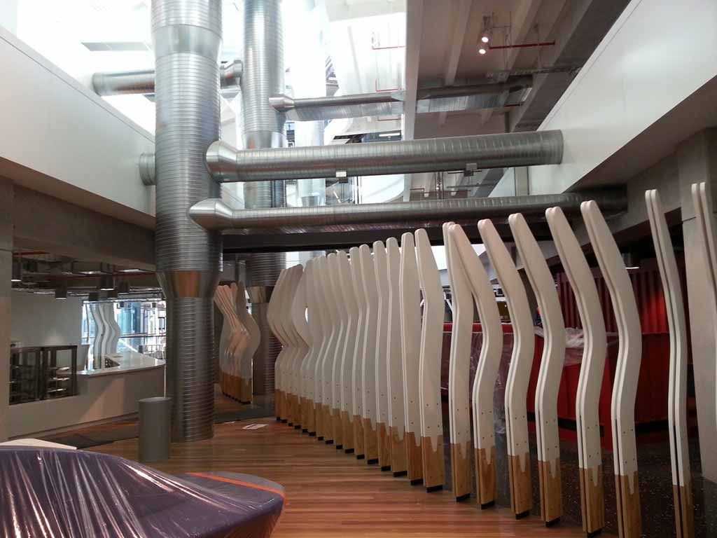 Modern interior with curved white panels, metallic Ducting, and wooden floors.