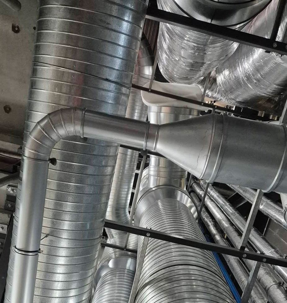 Metal ventilation ducts and pipes in an industrial setting.
