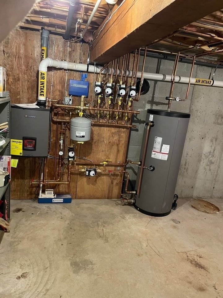 A basement with a lot of pipes and a water heater.