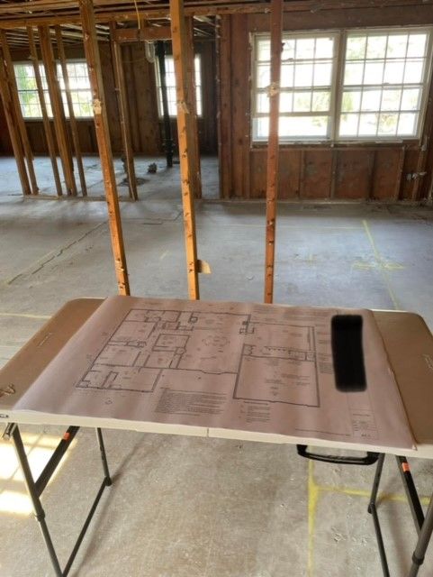 A folding table with a floor plan and a cell phone on it