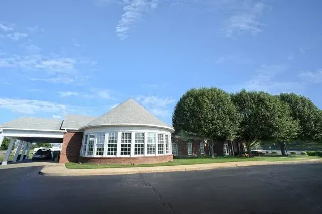 A large white building with a brown roof and a lot of windows.