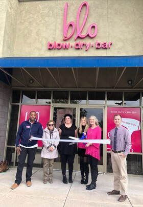 People cutting ribbon in front of a