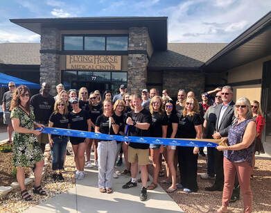 People cutting a ribbon at the grand opening of the