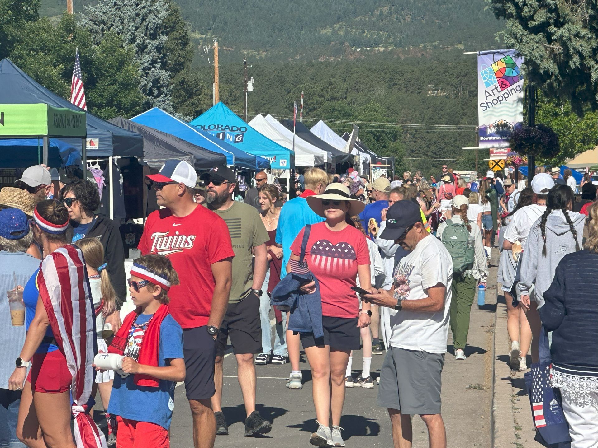 Attendees walk the 4th of July Tri-Lakes Chamber street fair