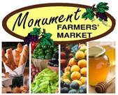 Monument Farmers' Market logo with fresh produce: bread, grapes, lemons, and honey.