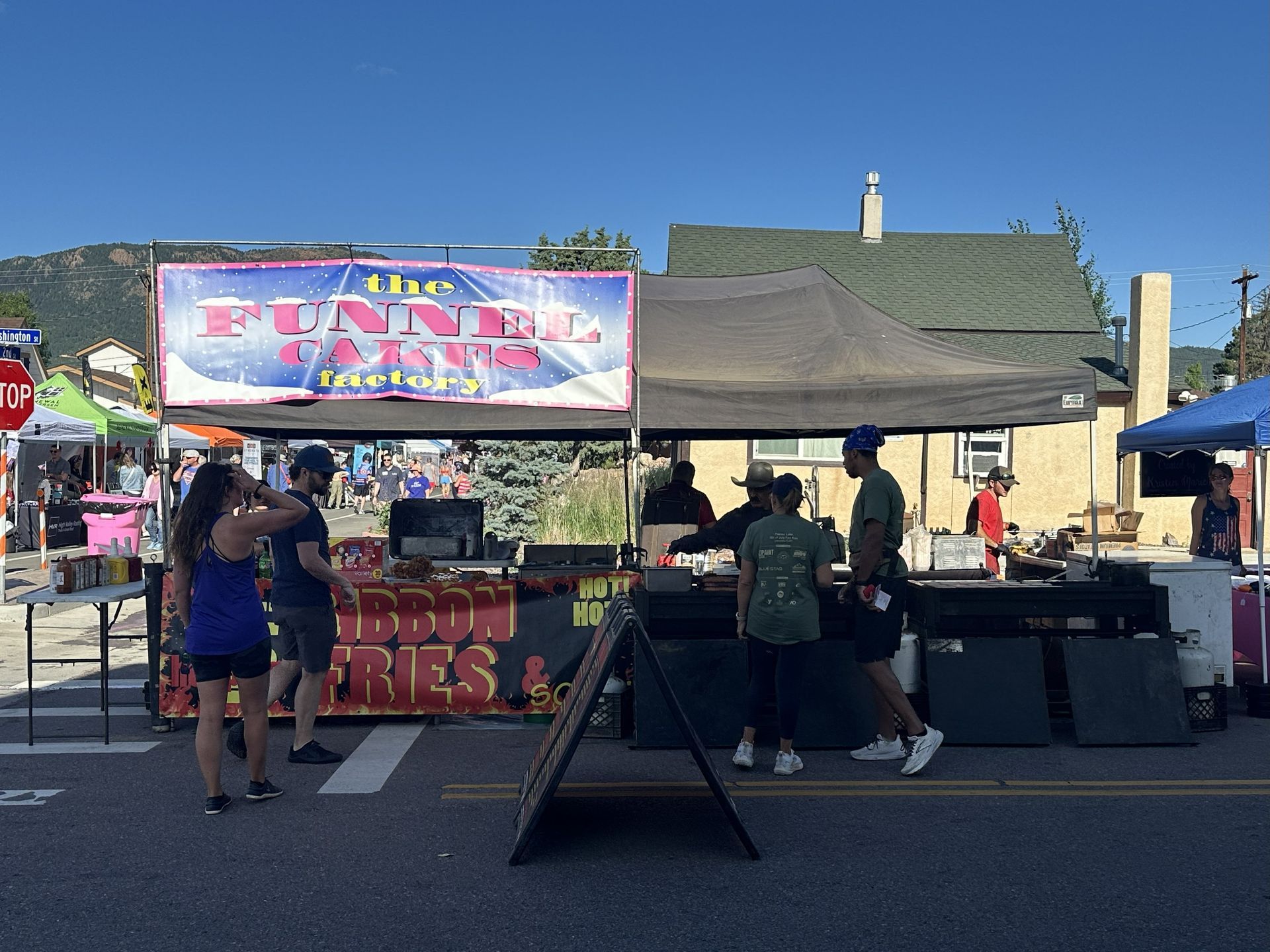 A vendor serving funnel cake at the 4th of July street fair