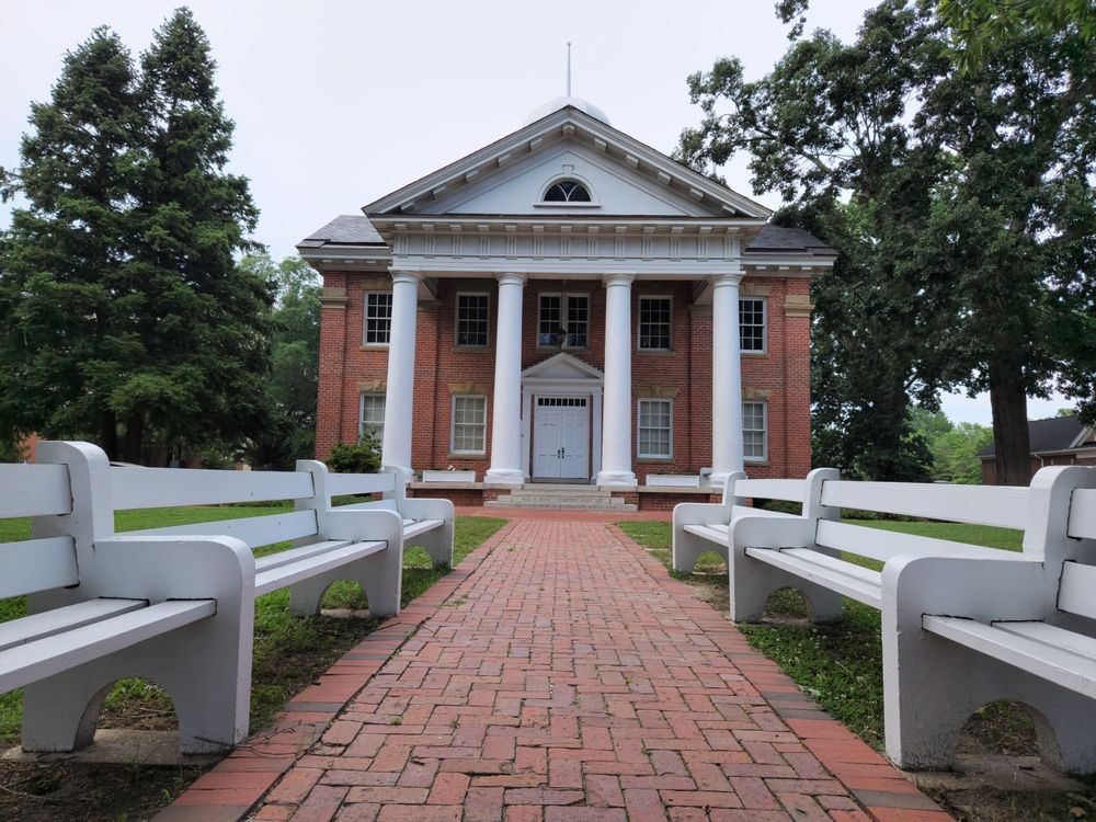 A brick building with white benches in front of it