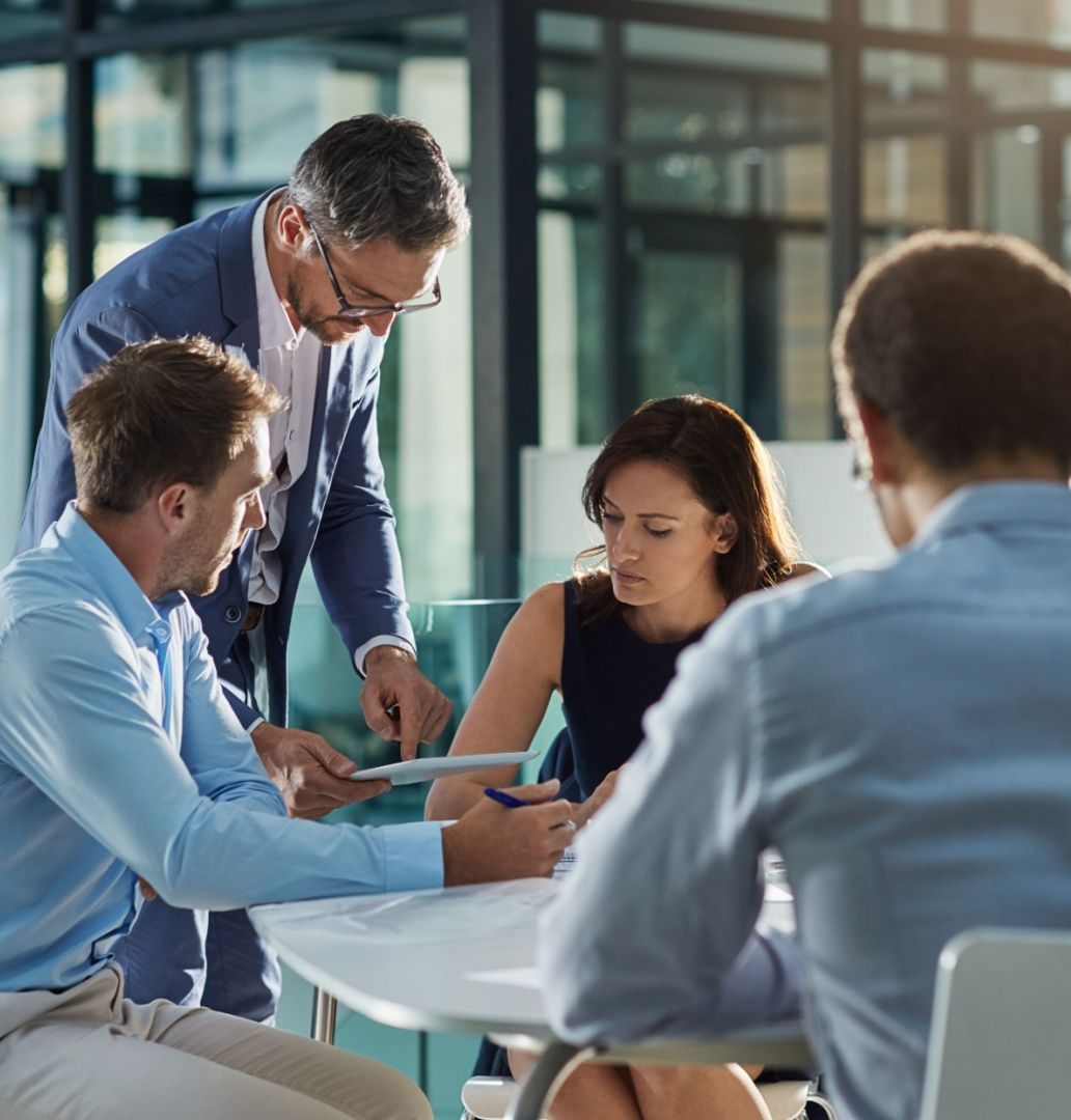 Coworkers are gathered at a table for IT consulting services.