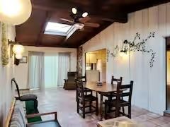 A living room with a table and chairs and a ceiling fan.