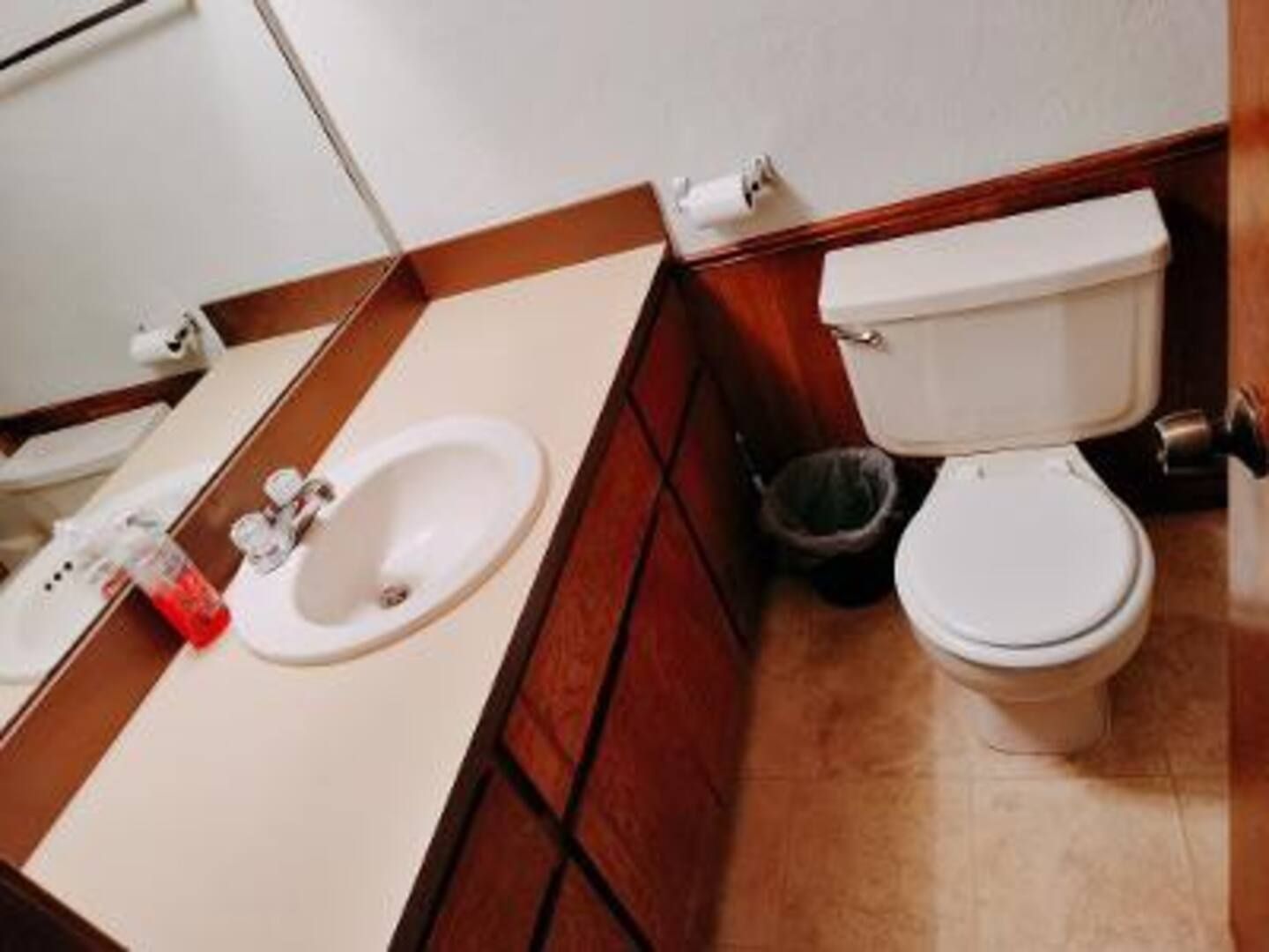 A bathroom with a toilet sink and mirror