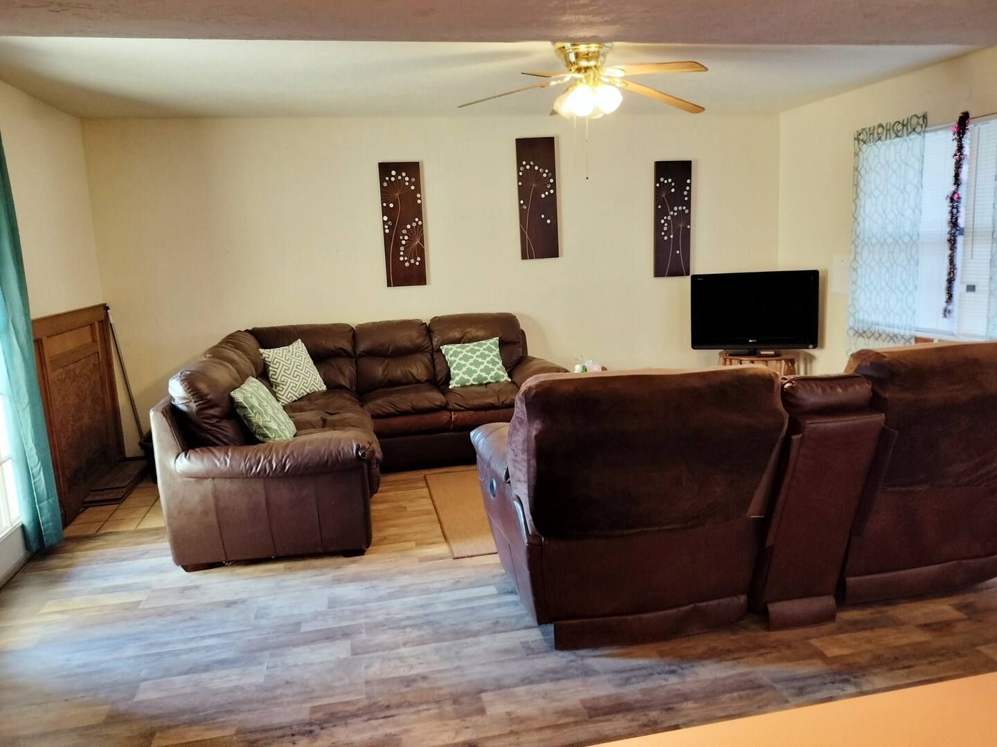 A living room with a sectional couch and a flat screen tv