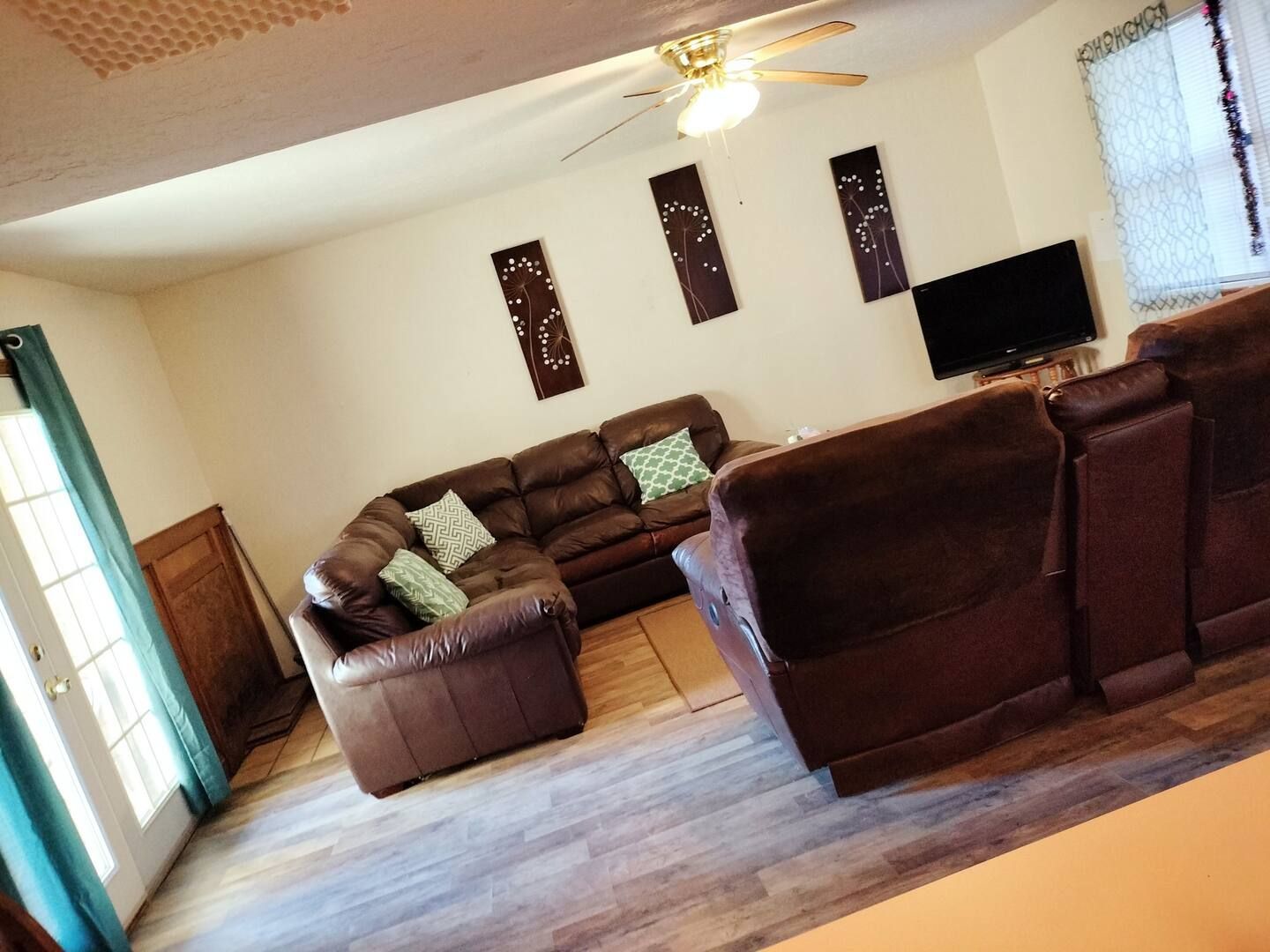 A living room with a sectional couch and a flat screen tv