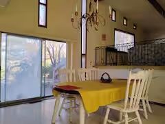 A dining room with a table and chairs and a chandelier.