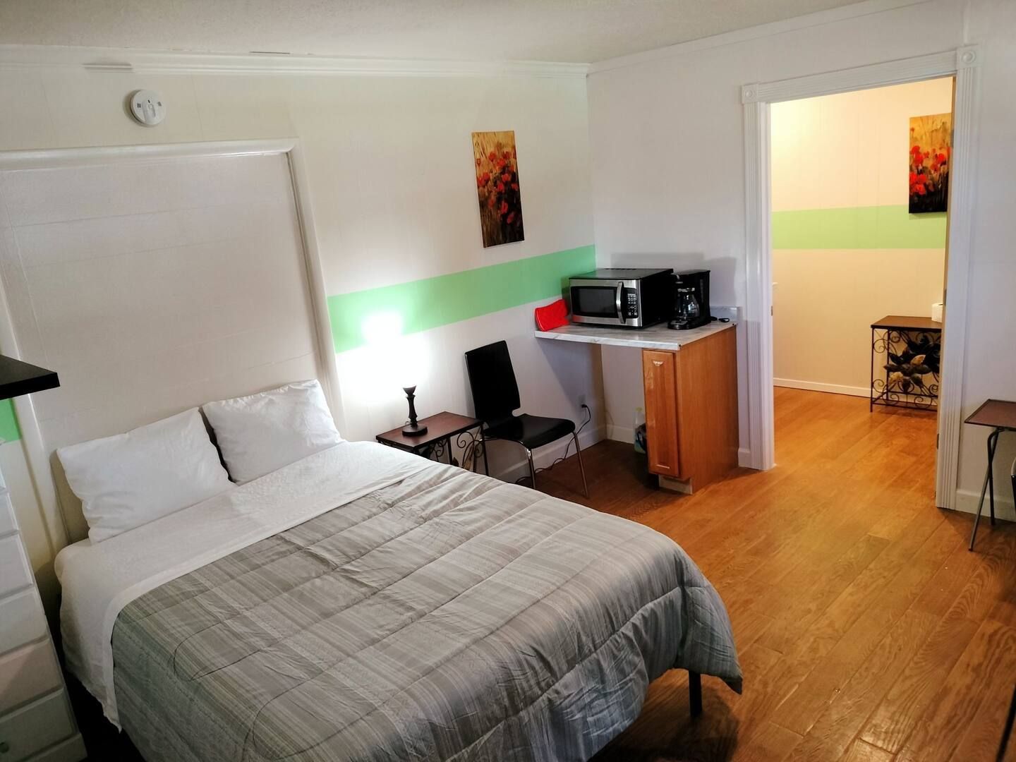 A hotel room with a bed and a microwave
