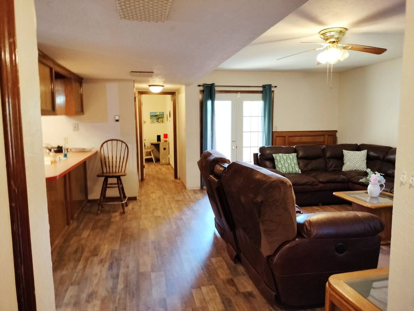 A living room with a couch and chairs and a ceiling fan