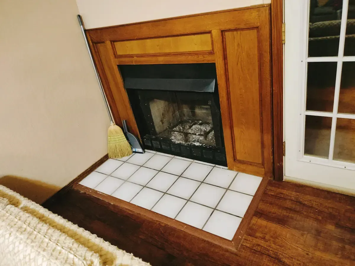 A fireplace with a broom in front of it