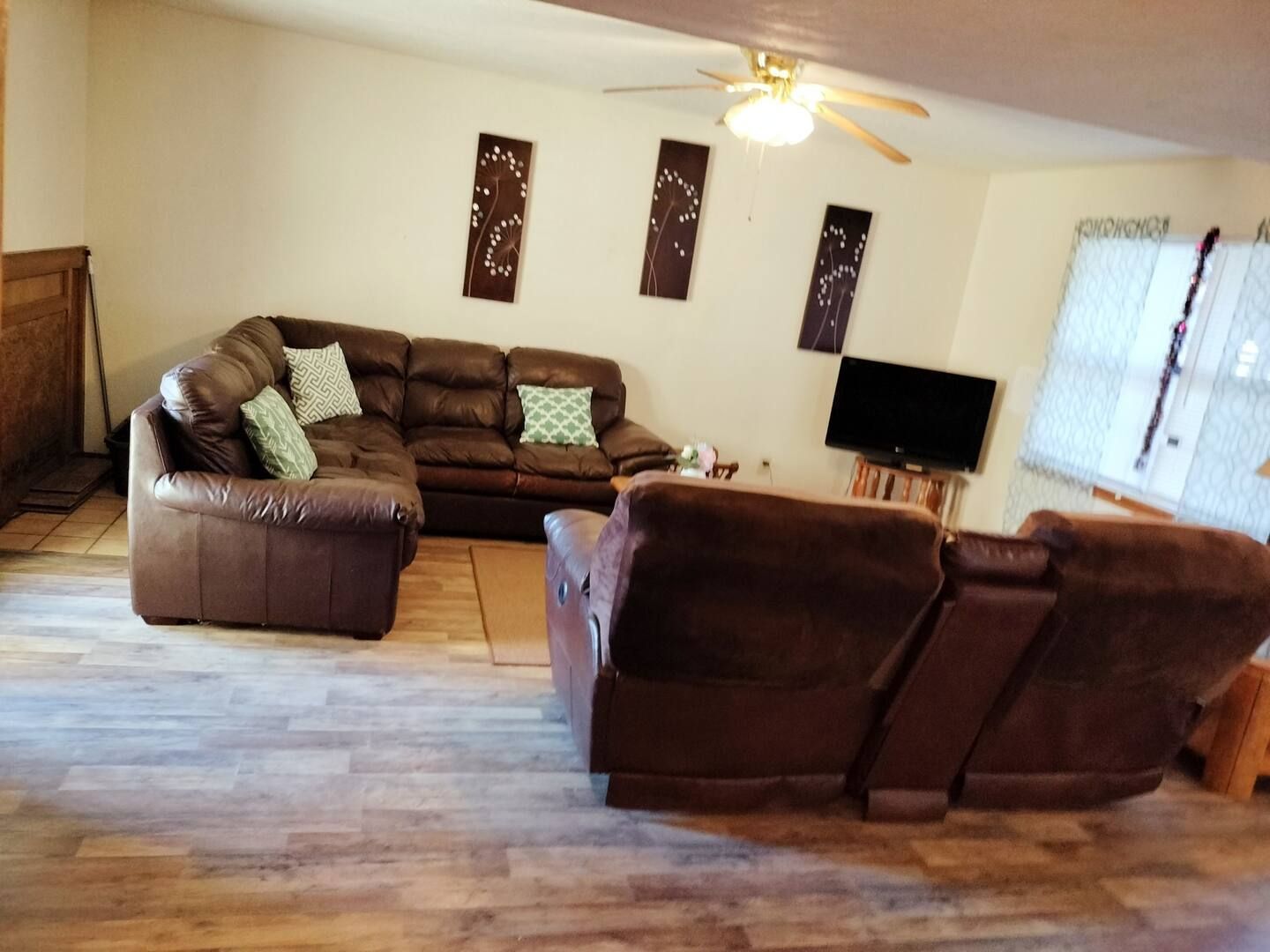 A living room with a sectional couch and a flat screen tv
