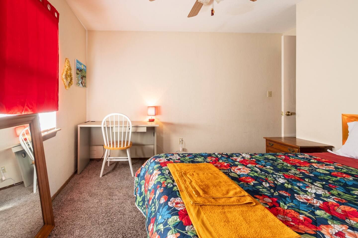 A bedroom with a bed , desk and chair.