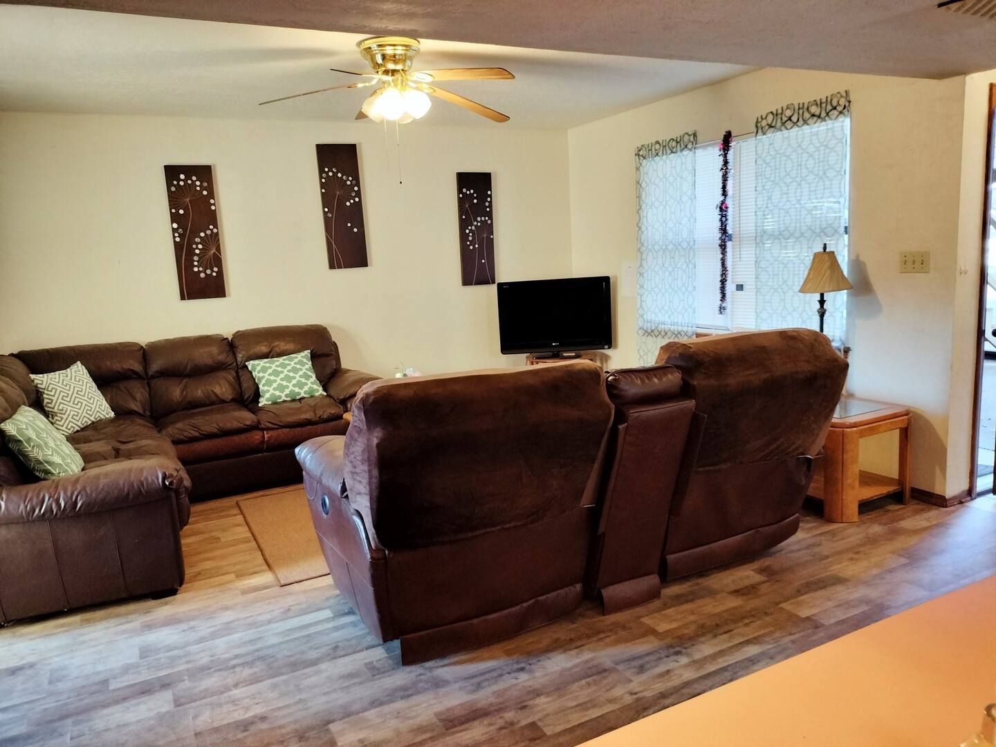 A living room with brown furniture and a flat screen tv