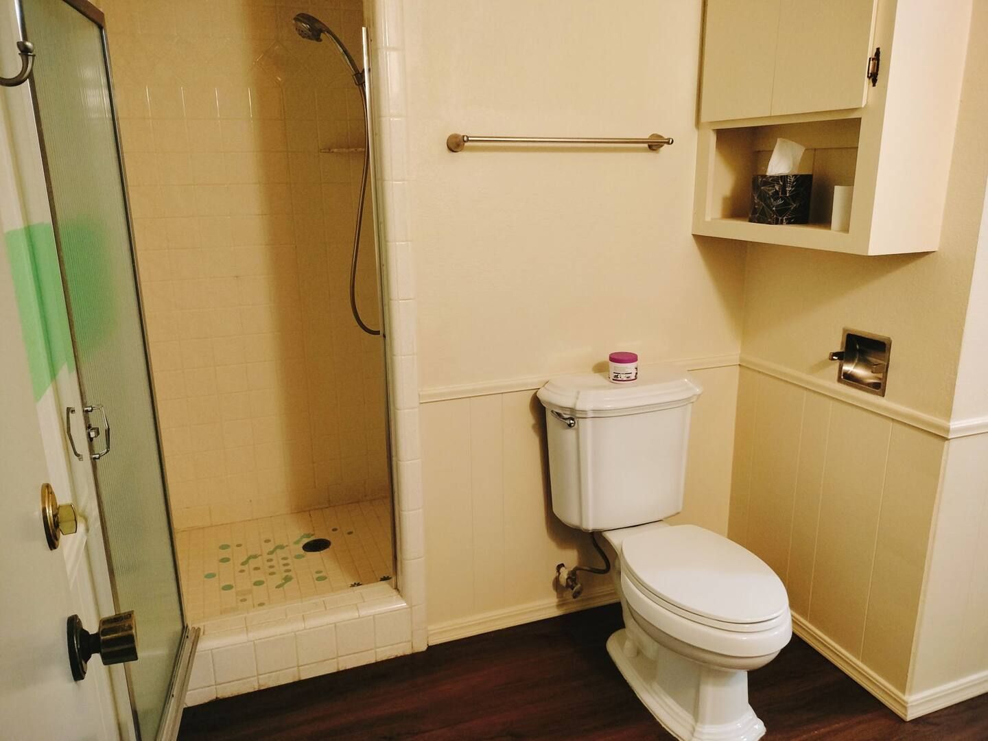 A bathroom with a toilet and a shower stall