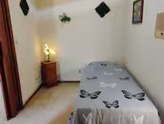 A bedroom with a single bed and a nightstand.