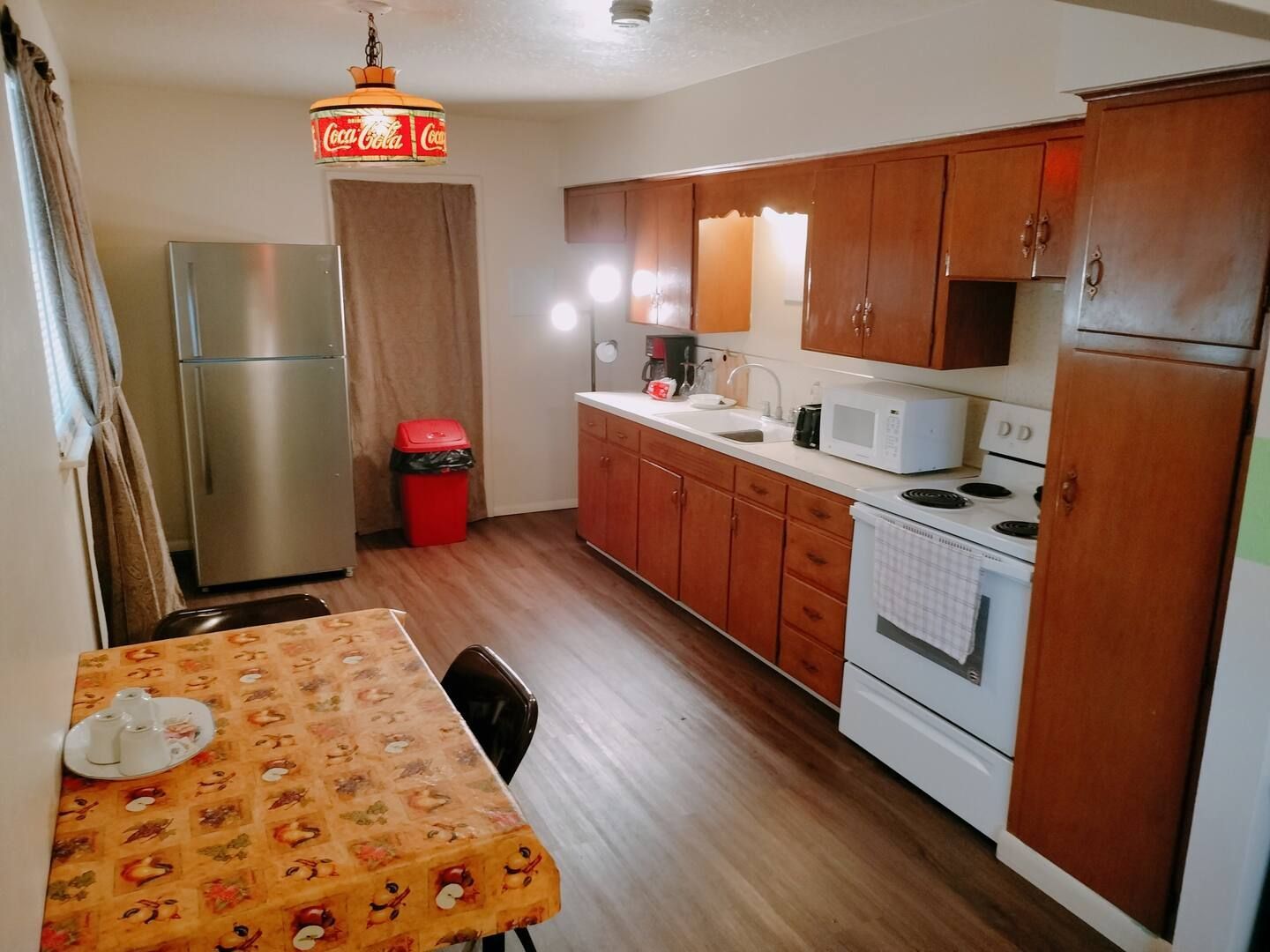 A kitchen with a coca cola sign hanging from the ceiling