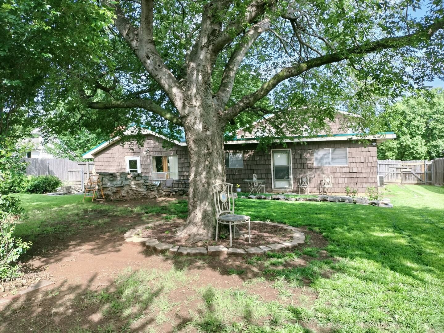 A house with a large tree in front of it.