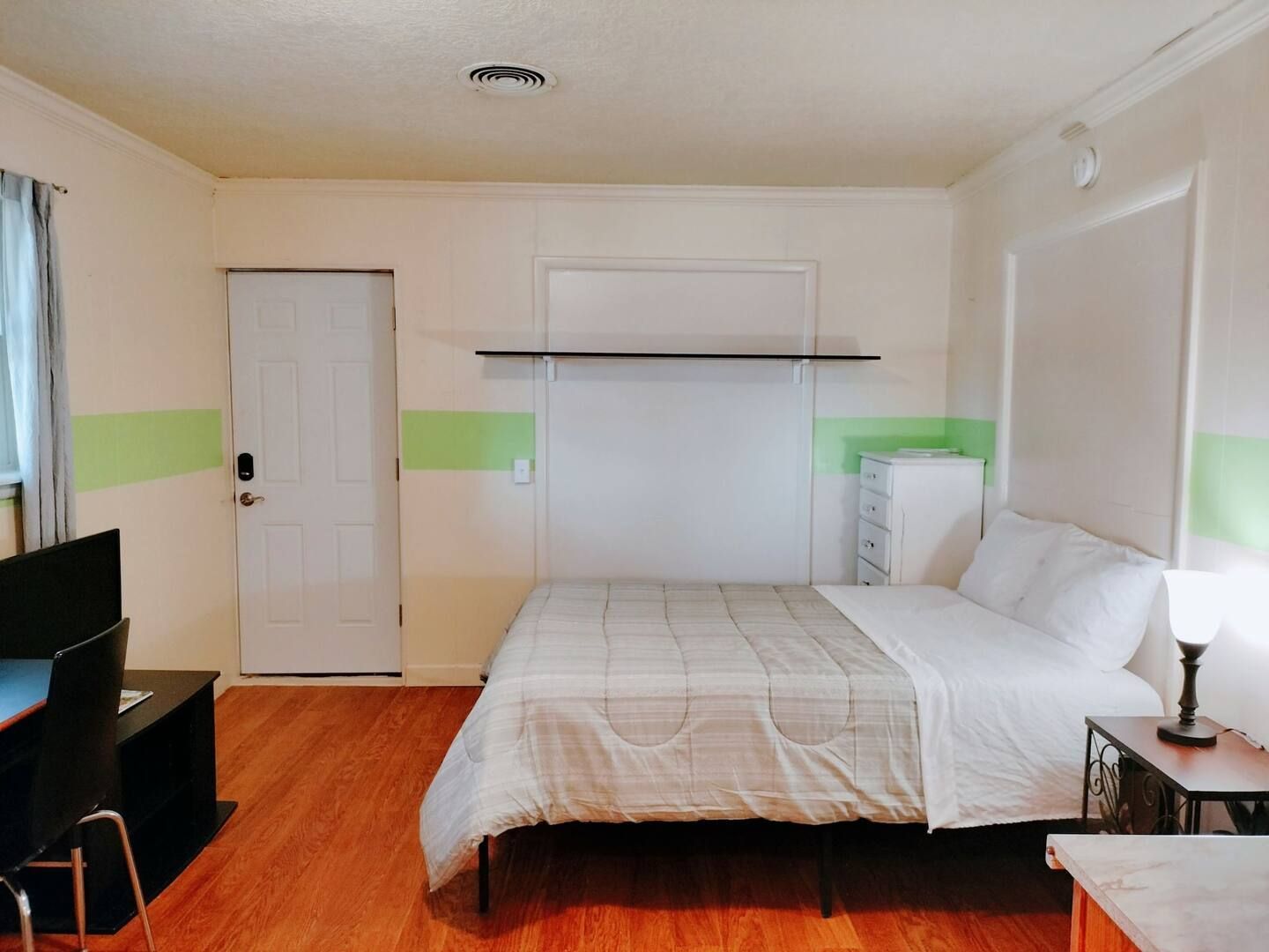 A hotel room with a bed and a television