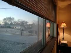 A window with blinds and a lamp in a room.