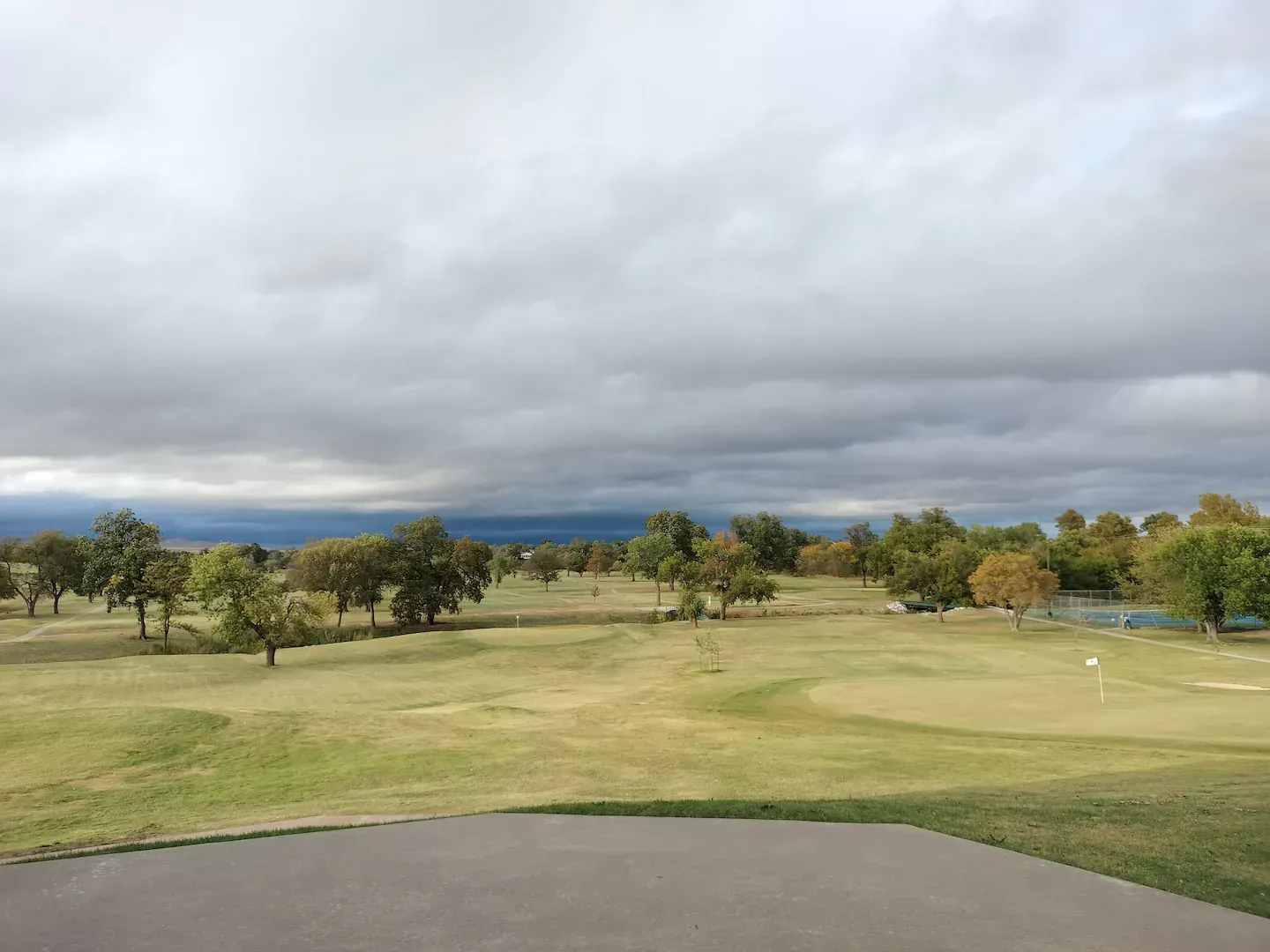 A view of a golf course on a cloudy day.