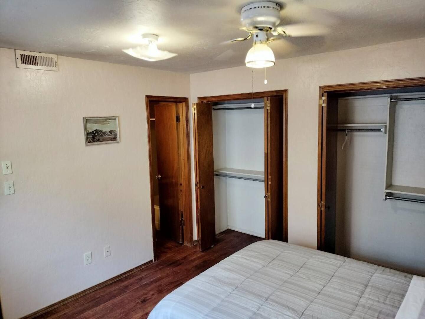 A bedroom with a bed and a ceiling fan