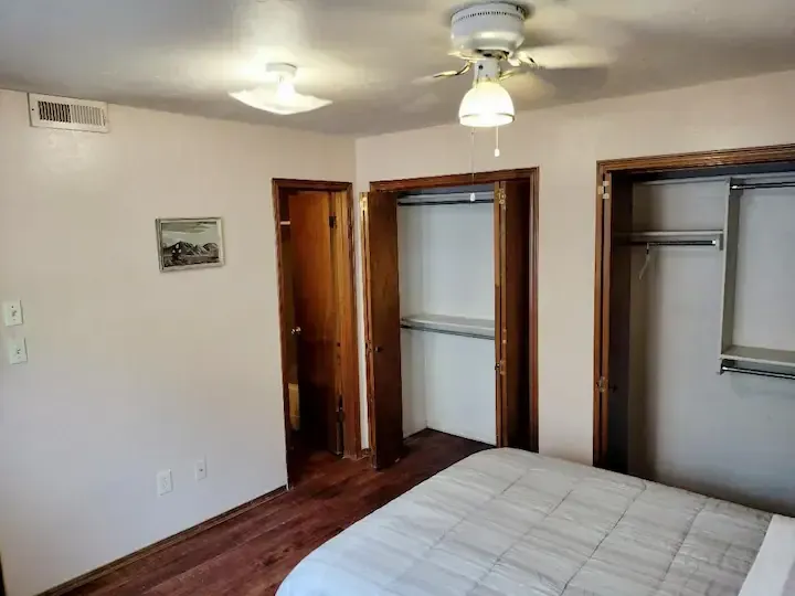 A bedroom with a bed and a ceiling fan